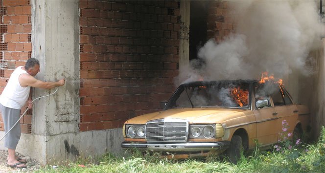 Alev alev yanan otomobilini hortumla söndürmeye çalıştı