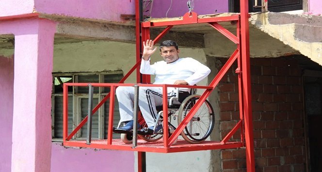 TÜRKİYE SAKATLAR DERNEĞİ KARABÜK ŞUBE BAŞKANI MUHİTTİN YILMAZ, GEÇEN YIL GEÇİRDİĞİ TRAFİK KAZASI SONUCU FELÇ GEÇİREN 41 YAŞINDAKİ ERDAL DALOĞLU’NUN MERDİVENLERİ EŞİNİN SIRTINDA İNİP ÇIKMASI ÜZERİNE EVİNİN ÖNÜNE 6 METRE YÜKSEKLİĞİNDE ASANSÖR YAPTI. (YASİN ERDEM/KARABÜK-İHA)