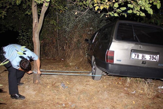 KARABÜK’TE PARK HALİNDE OLAN VE FRENİ BOŞALINCA HAREKET ETTİKTEN SONRA UÇURUMUN KENARINDA LASTİKLERİNE TAŞ KONULMASI SONRASI DURDURULAN OTOMOBİLİ OLAY YERİNE GELEN POLİS EKİPLERİ TARAFINDAN LASTİKLERİNDEN İPLE AĞACA BAĞLANDI. (YASİN ERDEM/KARABÜK-İHA)