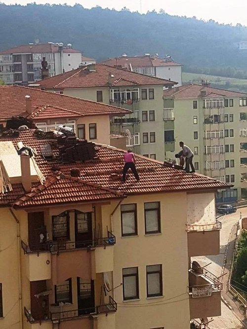 BARTIN'DA 6 KATLI BİR BİNANIN ÇATISINA ÇIKARAK GÜVENLİK ÖNLEMİ ALMADAN ÇALIŞAN İŞÇİLER OBJEKTİFLERE YANSIDI. (MUSTAFA KURT/BARTIN-İHA)