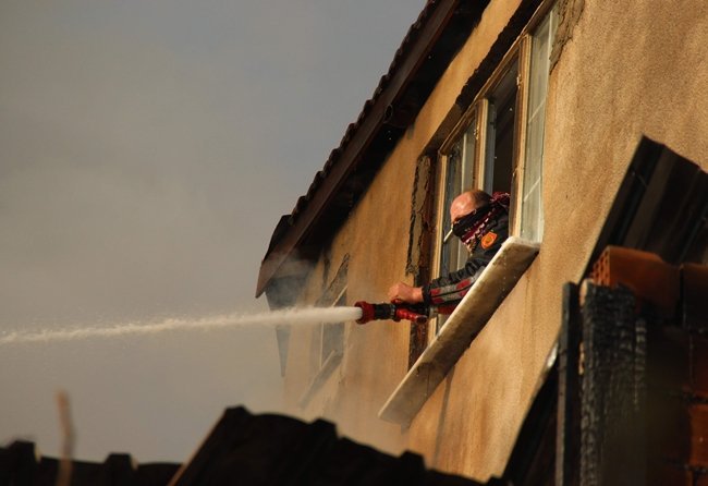 KERPİÇ EVİN YANINDA BULUNAN 3 KATLI BİNANIN SON KATINDAN YANGINA MÜDAHALE EDEN İTFAİYE EKİPLERİ YÜKSELENE DUMANLARDAN ETKİLENMEMEK İÇİN MASKE YERİNE AĞIZLARINI TÜLBENT İLE KAPATMASI İSE DİKKAT ÇEKTİ. (YASİN ERDEM/KARABÜK-İHA)