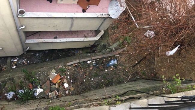 ZONGULDAK’TA BİR APARTMANIN İSTİNAT DUVARININ ÜZERİNDE BAHÇE KAZAN APARTMAN SAKİNİ, BİR ANDA DENGESİNİ KAYBEDİNCE APARTMAN BOŞLUĞUNU GEÇİP KENDİSİNİ YAKLAŞIK 3 METRE AŞAĞIDAKİ KOMŞUSUNUN BALKONUNDA BULDU. (ÖMER TEKCAN - ONUR ALTINDAĞ/ZONGULDAK-İHA)